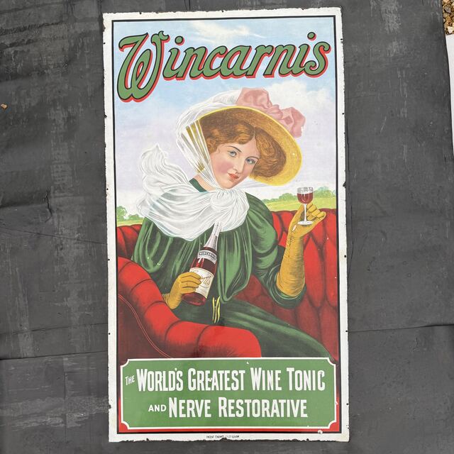 Wincarnis pictorial enamel advertising sign showing an Edwardian lady raising a glass of the wine tonic